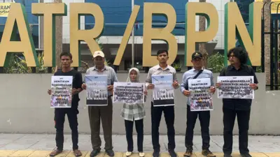 Sejumlah warga Air Bangis dan aktivis lingkungan memegang poster di depan gedung Kementerian ATR/BPN untuk memprotes perampasan lahan rakyat