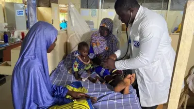 Le docteur Japhet Udokwu s'occupe d'un enfant, dans un centre de traitement pour enfants souffrant de malnutrition sévère à Damaturu, le 24 août 2022.