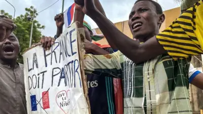 Men holding up a placard at a rally