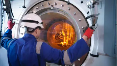 یک مهندس در نیروگاه هسته‌ای مقابل دستگاه سوخت آن را تنظیم می‌کند