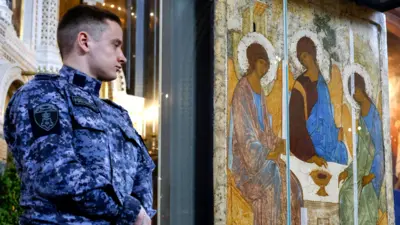 A Russian police officer stands guard near the icon Trinity by Andrei Rublev during a church service on Holy Trinity in the Cathedral of Christ the Savior in Moscow, Russia, on 4 June 2023