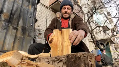 Valeri Dmitrenko, 45, chops wood to heat the basement where he and 21 neighbours have been sheltering for the past nine months