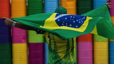مردی پرچم برزیل را بر شانه‌هایش گذاشته