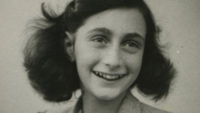 Anne Frank smiles in a black and white photo
