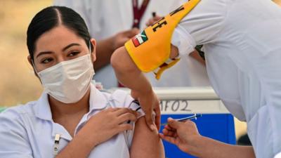 Una joven se vacuna de covid en México.