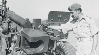 (Original Caption) Gift Gun...A Royal Pakistan Artillery sergeant inspects a 105mm Howitzer supplied under the U.S. Military Aid Program. Medium tanks, communication equipment and engineering supplies are among other major items being furnished Pakistan by the U.S. A team of instructors from Ft. Sill, Oklahoma, has been sent to the Pakistan Artillery School at Nowshera to train Pakistan Army officers in the use of the equipment. The officers will pass along the training to Pakistani troops. The veil of super-secrecy surrounding the aid program was lifted recently when newsmen got a look at the Nowshera installation.