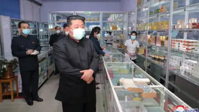 North Korean leader Kim Jong-un wears a facemask during a visit to a Pyongyang pharmacy