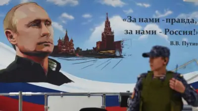 Putin on a poster with a police man