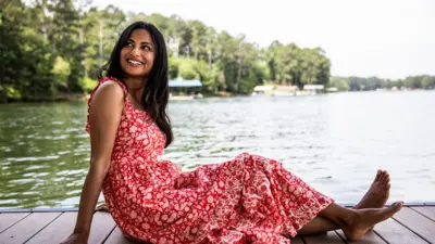 Woman with smartphone on dock at lake