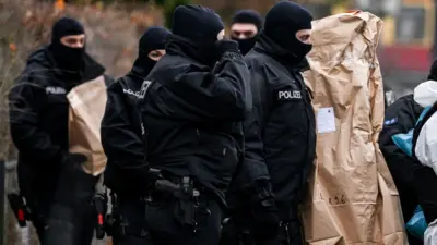 Policía alemana con objetos incautados en la redada