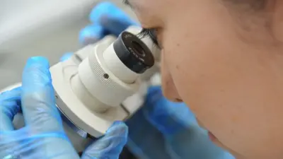 Cientista olha pelo microscópio