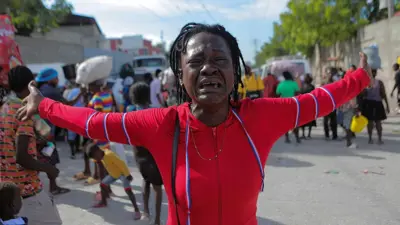 Une femme pleure alors que d'autres personnes fuient Port-au-Prince en raison de la violence, le 19 novembre 2022.