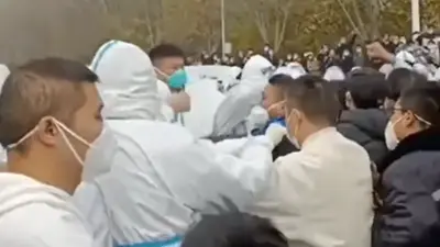 Tayangan video menunjukkan ratusan pekerja berdemo dan beberapa di antara mereka dikonfrontasi oleh orang-orang berpakaian APD (alat pelindung diri) dan polisi anti huru-hara di pabrik Foxconn di Zhengzhou 23/11