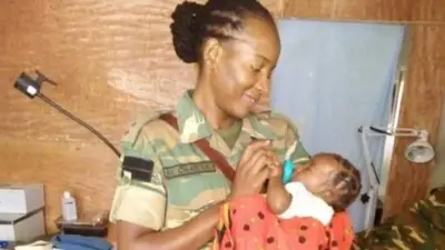 Le capitaine Mwila Chansa allaitant Thabo, sa fille adoptive d'origine centrafricaine