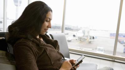 A woman using her phone at an airport