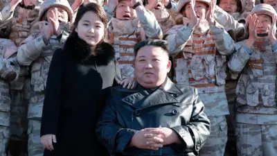 North Korean leader Kim Jong Un and his daughter attend a photo session with the scientists, engineers, military officials and others involved in the test-fire of the country's new Hwasong-17 intercontinental ballistic missile