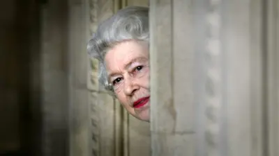Queen Elizabeth II peers round a corner during a visit to the Royal Albert Hall in London, marking the end of an 8 year restoration program.