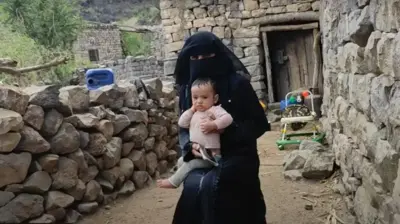 Mona dengan bayi laki-lakinya, Jarrah, di rumahnya di Mahweet, barat laut Yaman