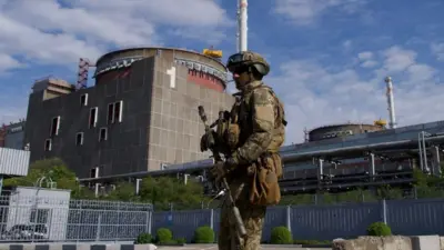 A Russian soldier stands guard outside Zaporizhzhia nuclear power plant