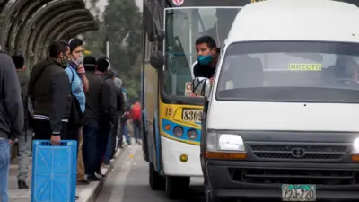Vehículos dedicados al transporte público en Lima tratan de captar pasajeros en una parada.