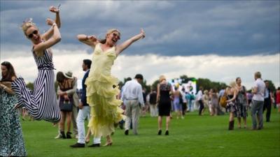 Two guests jump into the air for their friend's photograph during half-time at the Cartier International Polo day