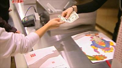A shopper hands over money at a department store.