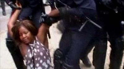 Woman being moved by police officers