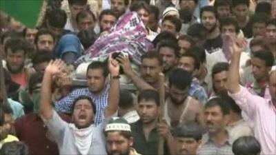 Crowds of protesters carrying body