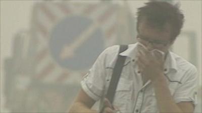 Man covers face while walking through smog in Moscow