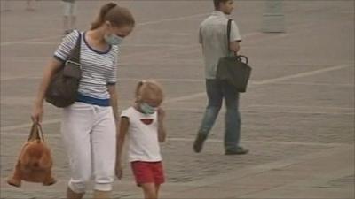 Masked woman and child in Moscow