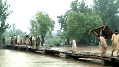 Villagers cross a bridge from Khazana