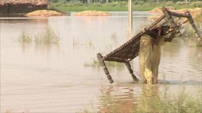 Flood survivor carrying furniture