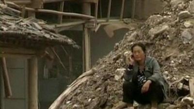 A woman sits on the rubble