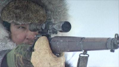 A Canadian Inuit aims at a seal