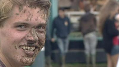 A teenager caked in mud