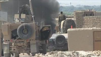 Military vehicle with smoke in background