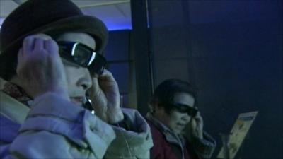 People trying on 3D glasses to watch television