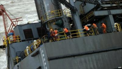 Chinese oil rig workers clinging to side of damaged oil rig