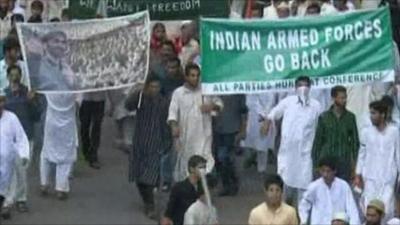 Protesters holding banner saying "Indian armed forces go back"