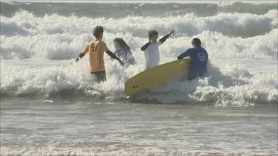 NHS patients in the sea with surf boards