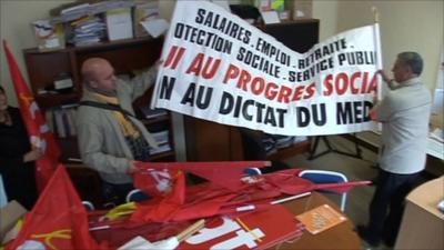 Room with campaign materials and men holding up banner