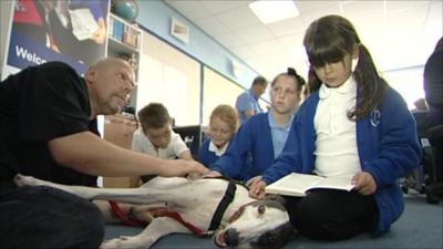 Dog helps children read in a classroom