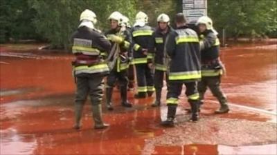 Firemen standing in the sludge