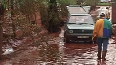 Man and car on road covered in toxic mud