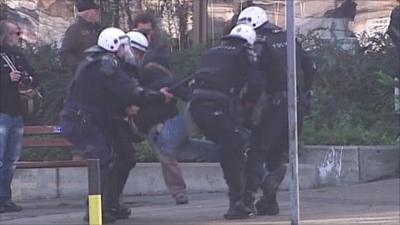 Police in Belgrade tackle a protestor