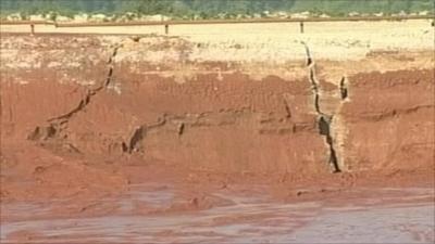Cracks widened at a burst reservoir that spilled toxic sludge