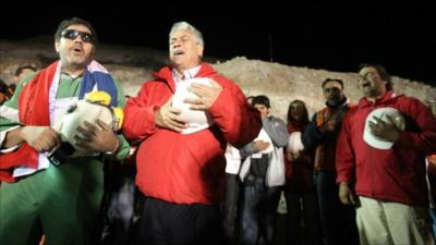 Chile's president Sebastian Pinera stands with chief supervisor Luis Urzua