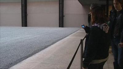 Visitors look at porcelain seeds at Tate gallery