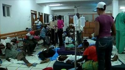 Patients in medical facility lying on floor and benches