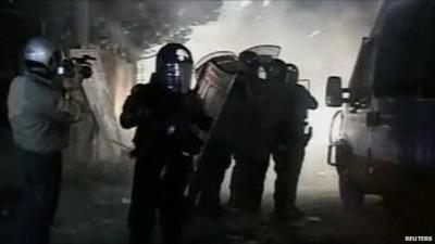 Riot police shield themselves from fireworks